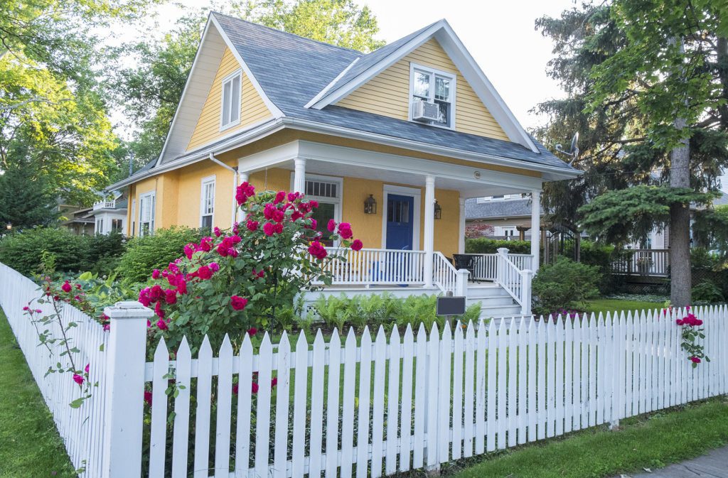A charming white picket fence surrounding a home