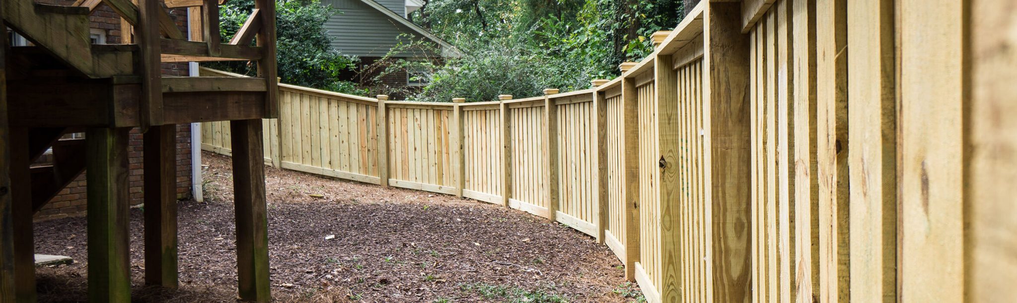 A tall cedar fence wrapping around a large backyard.