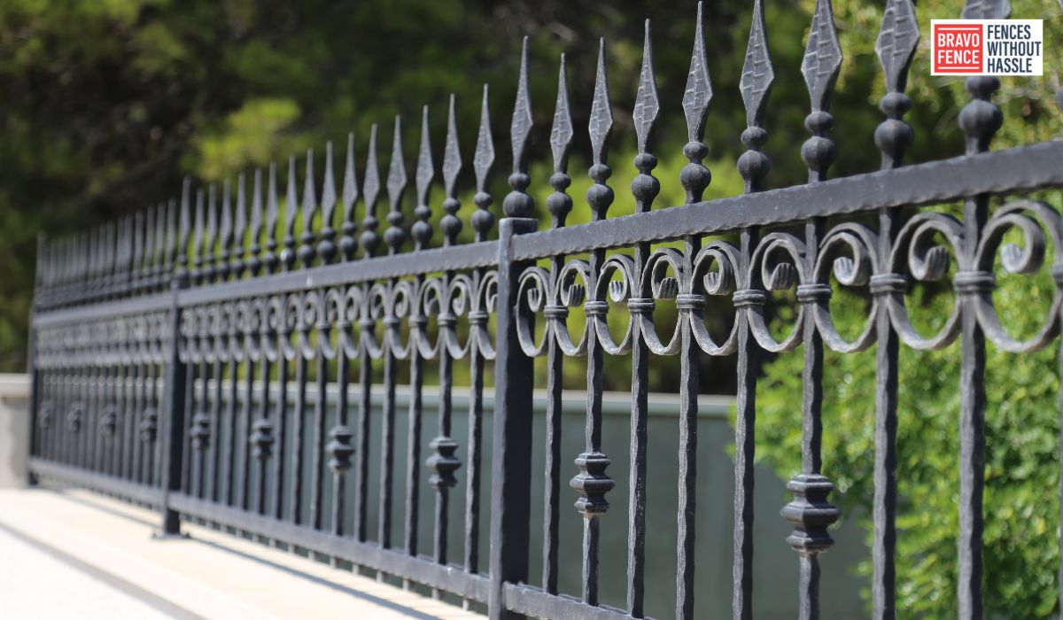 Handyman painting metal fence