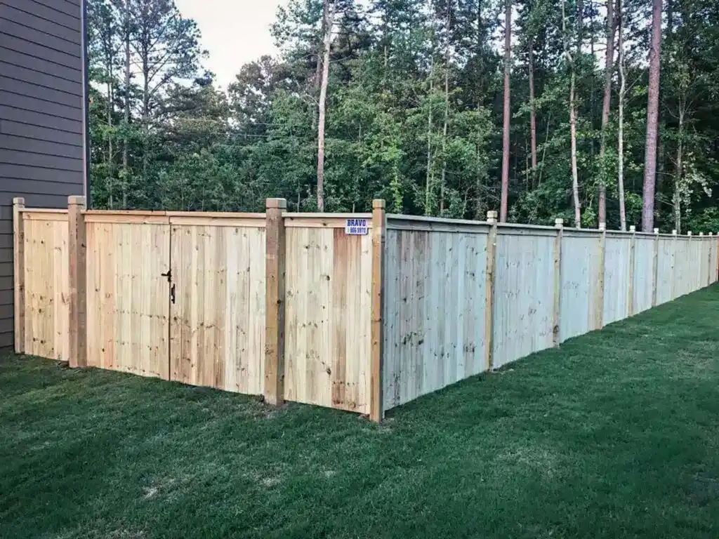 Capped wood privacy fence with dado-post design.