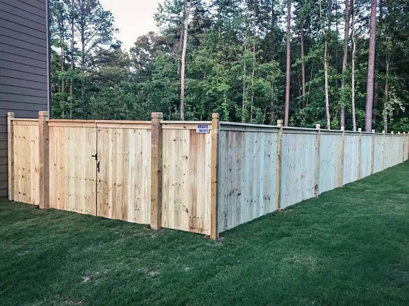 Capped wood privacy fence with dado-post design.